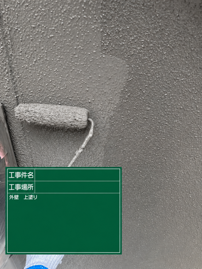 【上塗り｜高級感のあるグレーの外壁に仕上げる】<br />
中塗りの後、最後の塗装工程となる上塗りを行いました。<br />
<br />
上塗りは、塗膜を仕上げるとともに、住宅の外観を決定する工程です。<br />
<br />
施工前の外壁は、経年によってくすんだ印象のクリーム色でしたが、塗装後は落ち着いたグレーへと変わりました。<br />
<br />
グレーは光の当たり方によって明るさや濃淡の印象が変わり、住宅全体に落ち着きと高級感を与える色です。